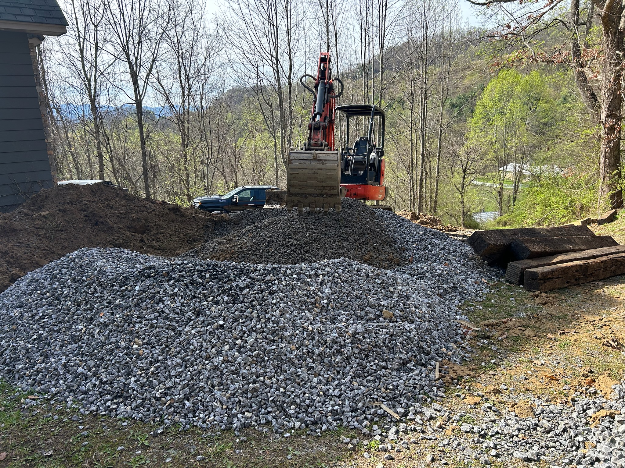 Kubota excavator on gravel pile, WNC valley